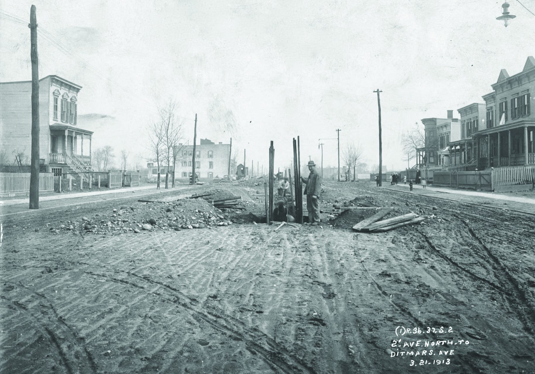 Photo Queens Historical Society: In a photo taken on March 21, 1913, we see workers digging a trench in the middle of 31st Street one block before Ditmars Boulevard in preparation for the start of construction of the elevated line. 